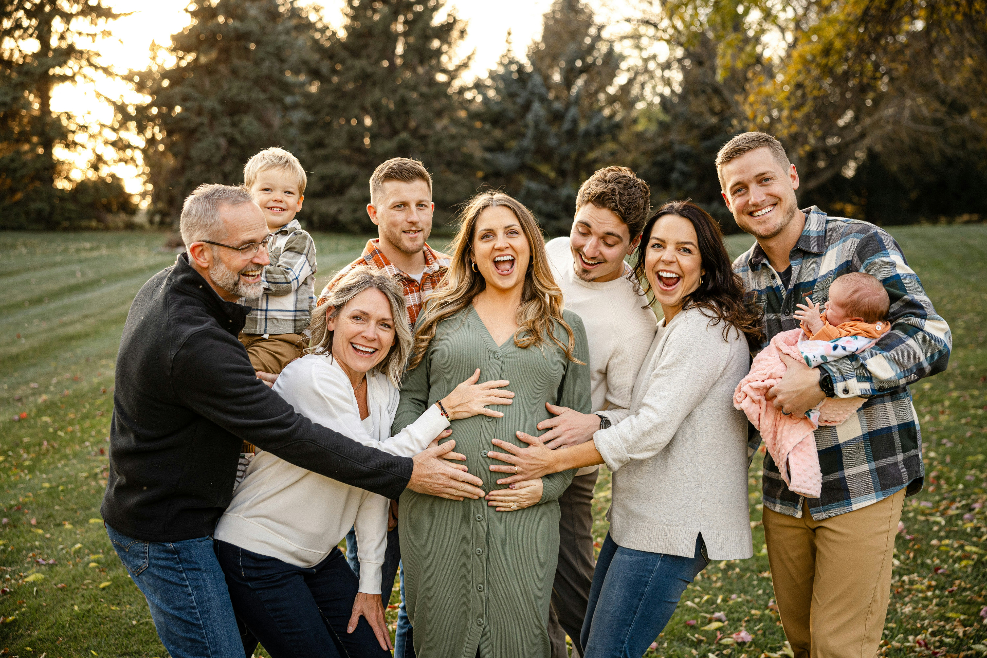 Multi-generational family laughing together outdoors at golden hour